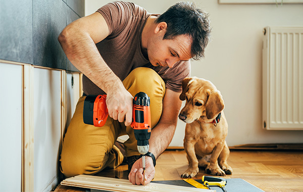 Photo of a man with tools doing construction on his home