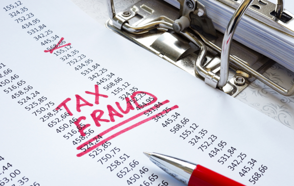 There is a printout of calculations with the words "Tax fraud" written on it in red ink