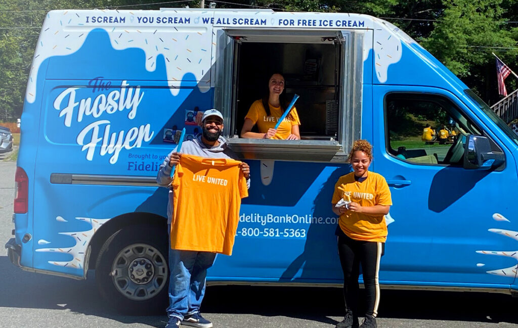 Image of Fidelity Bank's Frosty Flyer truck with happy people standing in front of it